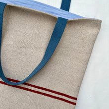 Load image into Gallery viewer, Tote bag. Heavyweight natural woven canvas with two horizontal red stripes. Lined with an ex-designer striped cotton shirting fabric.