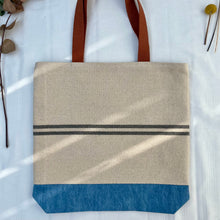 Load image into Gallery viewer, Tote bag. Heavyweight natural woven canvas with two horizontal blue grey stripes and light blue cotton denim bottom.