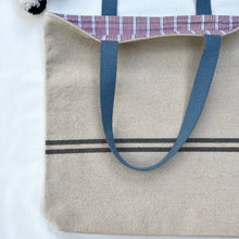 Load image into Gallery viewer, Tote bag. Heavyweight natural woven canvas with two horizontal blue grey stripes. Lined with a beautiful striped cotton shirting fabric.