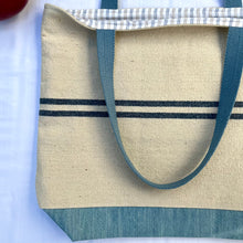 Load image into Gallery viewer, Tote bag. Heavyweight natural woven canvas with two horizontal blue stripes and light blue cotton denim bottom.