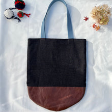 Load image into Gallery viewer, Tote bag. Luxurious fine wool fabric with small blue and brown squares and upcycled chocolate brown leather round bottom.