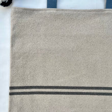 Load image into Gallery viewer, Tote bag. Heavyweight natural woven canvas with two horizontal blue grey stripes. Lined with a beautiful striped cotton shirting fabric.