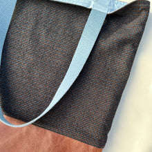 Load image into Gallery viewer, Tote bag. Luxurious fine wool fabric with small blue and brown squares and upcycled chocolate brown leather round bottom.