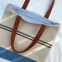 Load image into Gallery viewer, Tote bag. Heavyweight natural woven canvas with two horizontal blue grey stripes and light blue cotton denim bottom.