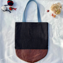 Load image into Gallery viewer, Tote bag. Luxurious fine wool fabric with small blue and brown squares and upcycled chocolate brown leather round bottom.