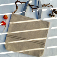 Load image into Gallery viewer, Tote bag. Heavyweight natural woven canvas with two horizontal sand-coloured stripes. Lined with a striped cotton shirting fabric.