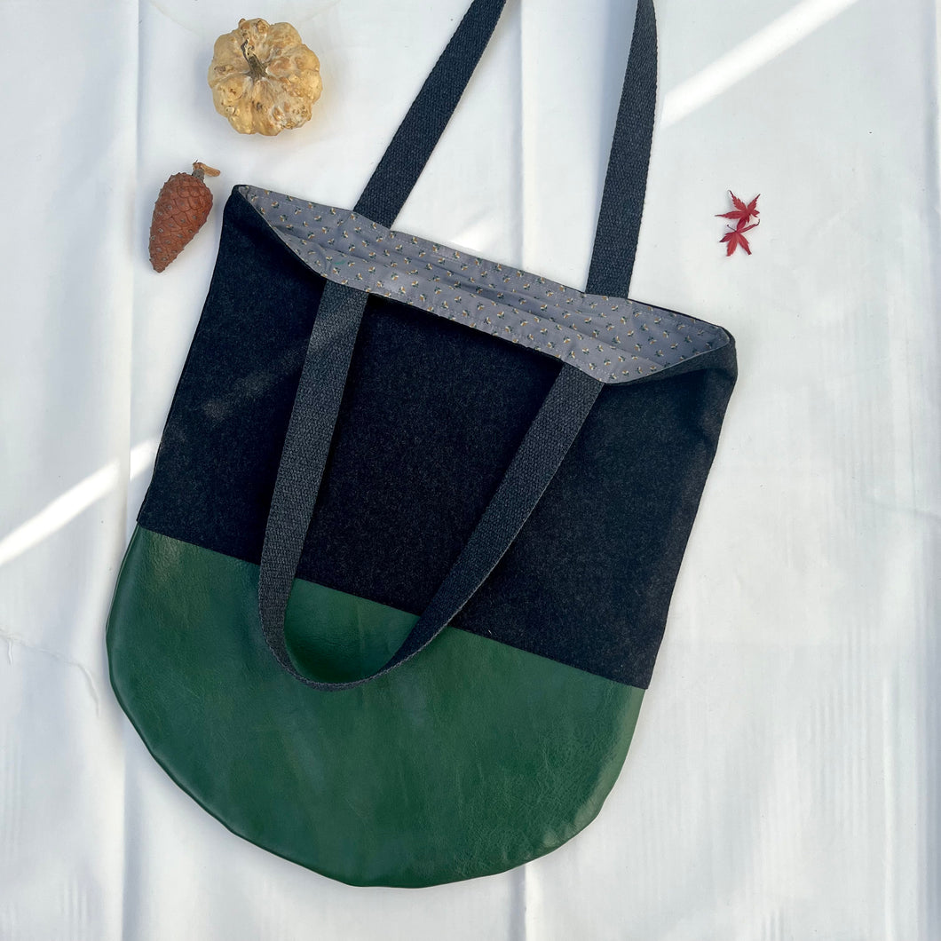 Tote bag. Dark grey wool tote with a green leather round bottom.