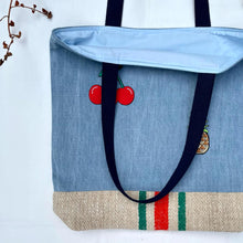 Load image into Gallery viewer, Unique tote bag. Light blue denim with embroidered patches and a vintage grain sack bottom.