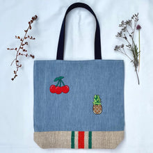 Load image into Gallery viewer, Unique tote bag. Light blue denim with embroidered patches and a vintage grain sack bottom.