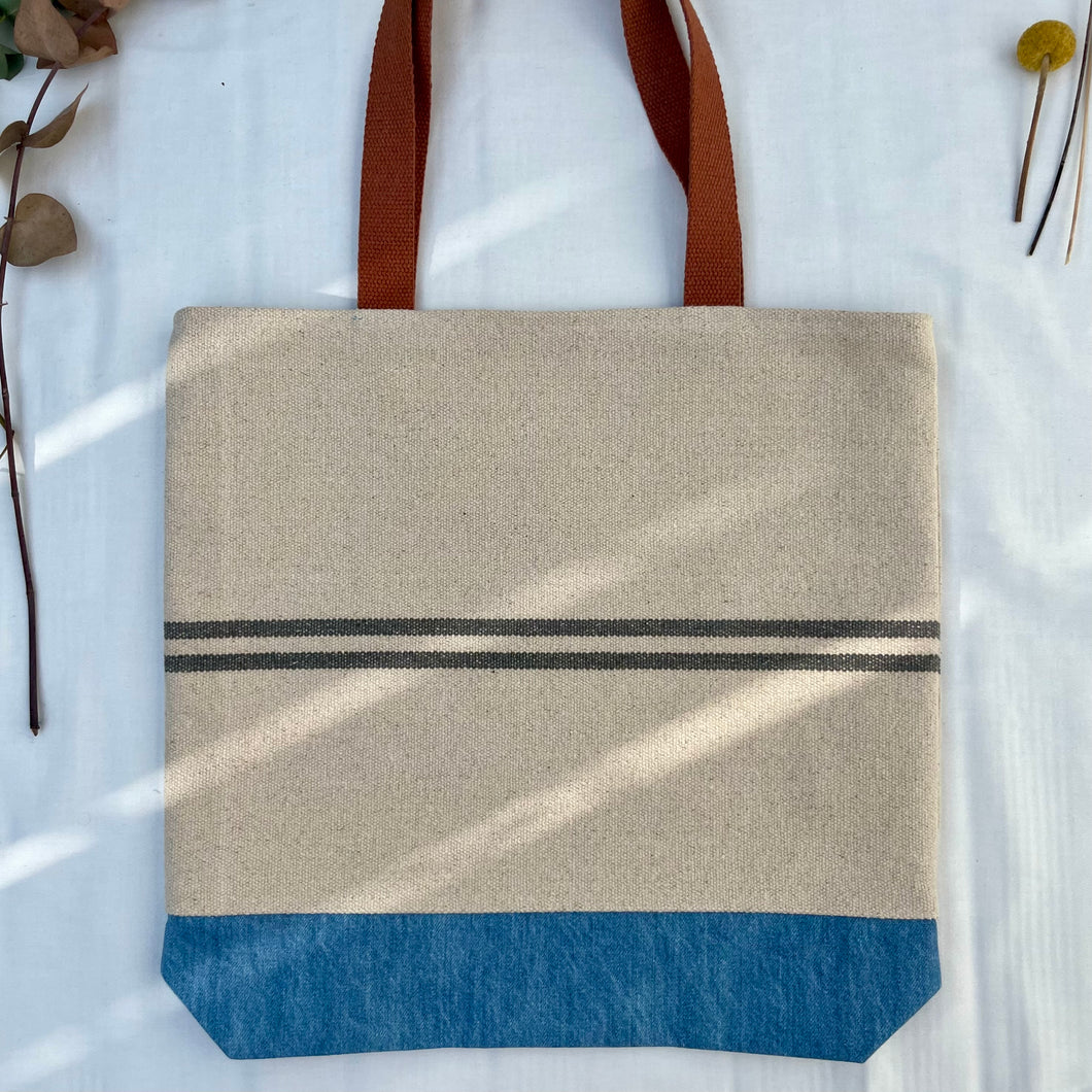 Tote bag. Heavyweight natural woven canvas with two horizontal blue grey stripes and light blue cotton denim bottom.