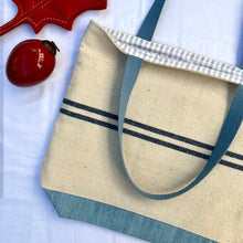 Load image into Gallery viewer, Tote bag. Heavyweight natural woven canvas with two horizontal blue stripes and light blue cotton denim bottom.
