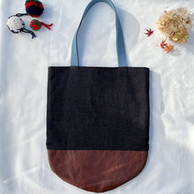 Load image into Gallery viewer, Tote bag. Luxurious fine wool fabric with small blue and brown squares and upcycled chocolate brown leather round bottom.
