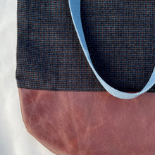 Load image into Gallery viewer, Tote bag. Luxurious fine wool fabric with small blue and brown squares and upcycled chocolate brown leather round bottom.
