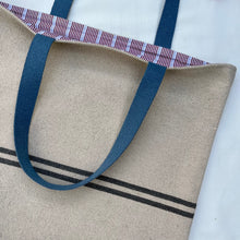 Load image into Gallery viewer, Tote bag. Heavyweight natural woven canvas with two horizontal blue grey stripes. Lined with a beautiful striped cotton shirting fabric.
