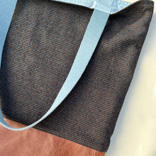 Load image into Gallery viewer, Tote bag. Luxurious fine wool fabric with small blue and brown squares and upcycled chocolate brown leather round bottom.
