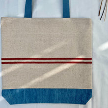 Load image into Gallery viewer, Tote bag. Heavyweight natural woven canvas with two horizontal red stripes and light blue cotton denim bottom.
