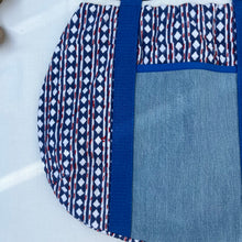 Load image into Gallery viewer, Block print bowling bag. Blue and white cotton print with red visible stitch. Red, navy blue and white knit cuff.
