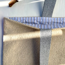 Load image into Gallery viewer, Tote bag. Heavyweight natural woven canvas with two horizontal sand-coloured stripes. Lined with a striped cotton shirting fabric.
