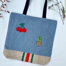 Load image into Gallery viewer, Unique tote bag. Light blue denim with embroidered patches and a vintage grain sack bottom.
