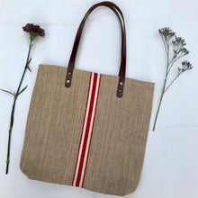Load image into Gallery viewer, Tote bag. Vintage grain sack tote bag with brown leather straps. Handwoven. Vertical red and leather white stripes.
