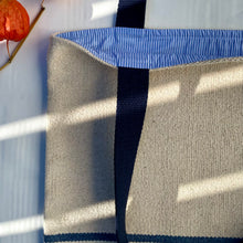 Load image into Gallery viewer, Tote bag. Heavyweight natural woven canvas with two horizontal blue stripes. Lined with a striped cotton shirting fabric.
