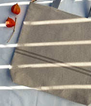 Load image into Gallery viewer, Tote bag. Heavyweight natural woven canvas with two horizontal sand-coloured stripes. Lined with a striped cotton shirting fabric.
