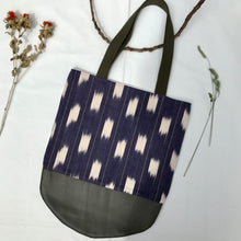 Load image into Gallery viewer, Tote bag. Ikat pattern fabric with a khaki green leather round bottom.
